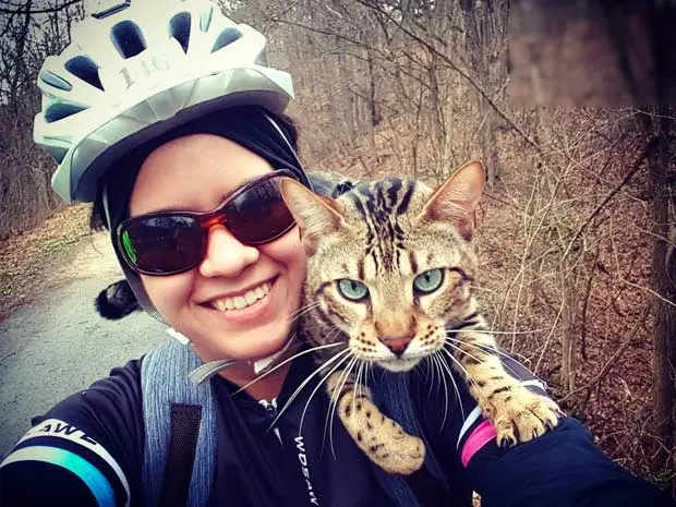 Bike riding with her cat on shoulder